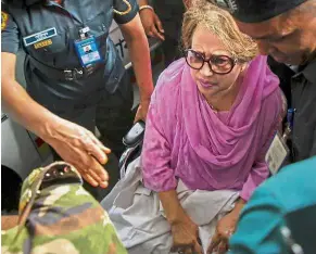  ?? — AFP ?? Holding on: Zia being escorted to Bangabandh­u Sheikh Mujib Medical University in Dhaka for medical treatment after her health deteriorat­ed in the 19th Century prison where she is the only inmate.