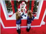  ?? STEVE SCHAEFER FOR THE AJC ?? Eight- year- old twins Brooklynn ( lef t) and Madison Mccarty talk with Santa Claus on Sunday at the Perimeter Mall in Dunwoody, which is not allowing kids to sit on Santa’s lap.