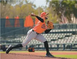  ?? KENNETH K. LAM/STAFF ?? Dillon Tate, who was one of Baltimore’s best relievers in 2022, was one of several pitchers who threw during live batting practice at Ed Smith Stadium on Friday.