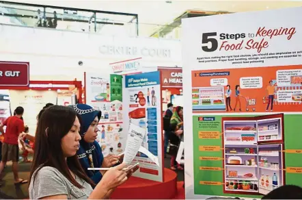  ??  ?? Visitors taking part in the Nutri-Info-Hunt challenge during Nutrition Month Malaysia 2017. — Handout