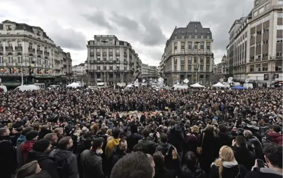  ?? MARTIN MEISSNER/THE ASSOCIATED PRESS ?? People observe a minute of silence at the Place de la Bourse in the centre of Brussels Wednesday to remember victims of the deadly terrorist bombings in that city.