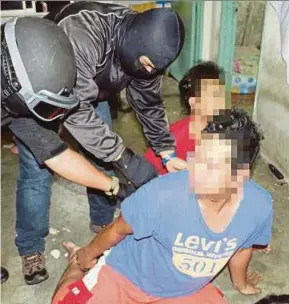  ??  ?? Anti-terrorism officers arresting two of the suspected Abu Sayyaf members in Kuala Lumpur last week.