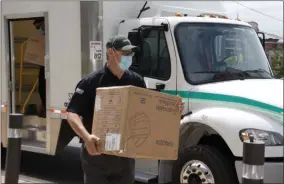  ?? SARATOGA COUNTY CHAMBER OF COMMERCE PHOTO ?? Keith Plummer of UniFirst carries a box of masks donated from the company to the Saratoga County Chamber of Commerce.