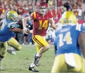  ??  ?? USC QUARTERBAC­K Sam Darnold runs away from UCLA’s Jacob Tuioti-Mariner in the second quarter.