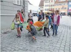  ?? FOTO: VERA STILLER ?? In einer Art Triumphzug wird der gefangenge­nommene Bär durch die Straßen der Stadt getragen.