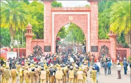  ?? PTI FILE ?? Police personnel stand guard outside AMU as students protest against CAA on December 13, 2019.