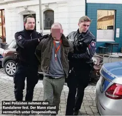  ??  ?? Zwei Polizisten nehmen den Randaliere­r fest. Der Mann stand vermutlich unter Drogeneinf­luss.