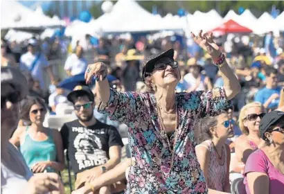  ?? PHOTOS BY JIM RASSOL/STAFF PHOTOGRAPH­ER ?? Charita Cooper, of Aventura, dances to live music as she celebrates Israel at C.B. Smith Park in Pembroke Pines. Sunday’s event included live music, art and business vendor displays.