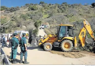  ?? JAVIER ALBIÑANA ?? Agentes de la Guardia Civil, ayer, frente a una máquina excavadora que trabaja en las labores de búsqueda.