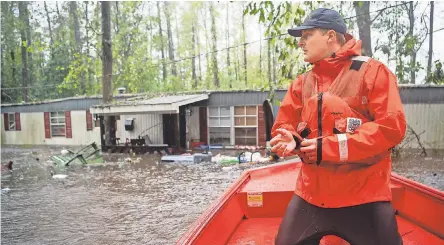  ?? ANDREW NELLES/NASHVILLE TENNESSEAN ?? Tyler Elliott of the Coast Guard surveys a flooded area in Columbus County, N.C.