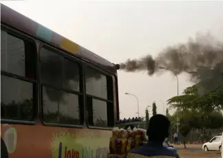  ?? Afolabi Sotunde/REUTERS ?? A man sells plantain chips near a bus with smoke seen from its exhaust at a bus park in Abuja, Nigeria.