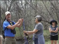  ?? Ella Cobb / Staff Writer ?? Martin Ogle, left, demonstrat­es how to make a rope out of hemp found by the creekside with the assistance of Dot Pisha’s hiking poles during Sunday’s Mother’s Day hike on Coal Creek Trail in Lafayette.