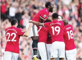  ??  ?? United players celebrate taking an early lead during a period of torrential downpour in the opening five minutes