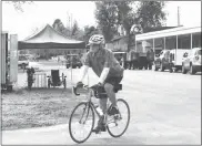  ?? Meghan G’Schwind ?? One of more than 300 riders who participat­ed in BRAN this year is shown pedaling by Callaway Public Schools. The majority of the bikers camped on the practice field which was cleaned up by volunteers after the June 5 storm.