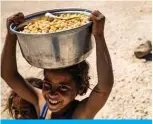  ??  ?? HASAKEH PROVINCE: A displaced Syrian girl carries a pot of chickpeas at the Washukanni camp for the internally displaced in Syria’s northeaste­rn Hasakeh province during the Muslim holy month of Ramadan. – AFP