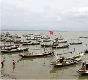  ?? ROBERTUS RISKY/JAWA POS ?? ISTIRAHAT DULU: Para nelayan memarkir perahu mereka di pesisir. Angin kencang dan ombak tinggi membuat mereka tak bisa melaut.