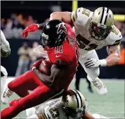  ?? David Goldman / AP ?? Atlanta’s Julio Jones (11) is hit by New Orleans’ Marshon Lattimore (23) and Manti Te’o (51) during the second half.