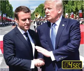  ??  ?? No letting go: President Trump pats Mr Macron’s hand several times