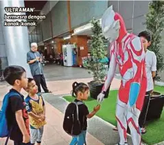  ??  ?? ‘ULTRAMAN’ bermesra dengan kanak-kanak.