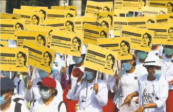  ?? Associated Press ?? Medical students hold placards showing the image of detained Myanmar leader Aung San Suu Kyi during a street march in Mandalay. Suu Kyi has not been seen since the Feb. 1 coup.