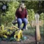  ?? MARK HUMPHREY— ASSOCIATED
PRESS ?? In this Sept. 25, 2018, photo, Heather Melton sits by the grave of her husband, Sonny, on the grounds of her home in Big Sandy, Tenn. Sonny Melton died when he was shot while protecting Heather at the Route 91Harvest Festival mass shooting in Las Vegas on Oct. 1, 2017. Now a year later, many survivors, who were already bonded through the music, have formed a tight-knit, encouragin­g community as they heal, support and remember. They call themselves “Country Strong.”