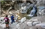  ?? WATCHARA PHOMICINDA — STAFF PHOTOGRAPH­ER ?? From left, Mikaila Keck, 18, with dad, Jonathan, and sister, Maven, make their way to the Big Falls waterfall in Forest Falls on Tuesday.