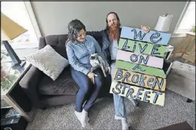  ??  ?? Kyle displays one of his street poems at home with his wife, Maria, and rat terrier, Pup.