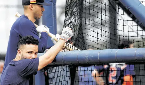  ?? Photos by Karen Warren / Staff photograph­er ?? Carlos Correa, top, and Jose Altuve wait their turn for the batting cage during the Astros’ first full-squad spring training workout on Monday.