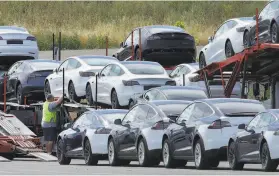  ?? Ben Margot / Associated Press ?? Tesla cars are loaded onto carriers at the company’s Fremont plant this week. It is narrowing its search for a new manufactur­ing site.