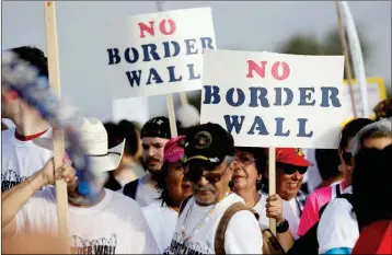  ?? ASSOCIATED PRESS ?? HUNDREDS OF PEOPLE march along a levee toward the Rio Grande to oppose the wall the U.S. government wants to build on the river separating Texas and Mexico Saturday in Mission, Texas.