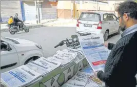  ?? ANI ?? ■ A man reads a newspaper in a closed market in Srinagar on Friday.