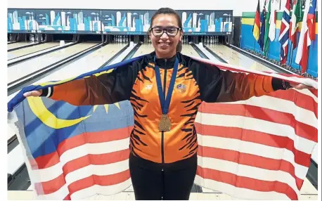  ??  ?? All smiles: Nur Syazwani Sahar posing for a photograph after beating Estefania Cobo of Puerto Rico 2- 0 in the second round of the World Youth Championsh­ips at the Thunderbow­l Lanes in Detroit on Thursday.