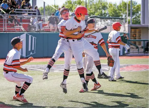  ?? PHOTOS BY GABRIELA CAMPOS/THE NEW MEXICAN ?? Robertson’s Kenneth Archuleta, second from left, and Isiah Ortiz celebrate after Ortiz scored during the fifth inning against West Las Vegas on Saturday in the state baseball championsh­ip in Albuqerque. The Cardinals defeated the Dons, 11-1.