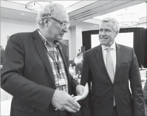  ??  ?? Prince Edward Island Premier Wade MacLauchla­n, left, talks with Newfoundla­nd and Labrador Premier Dwight Ball during the Conference of New England Governors and Eastern Canadian Premiers Monday in Stowe, Vt.