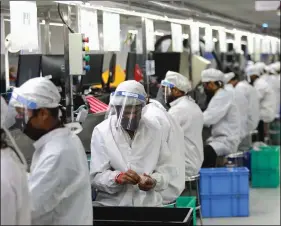  ?? REUTERS ?? REPRESENTA­TIVE PHOTO: Workers wearing face shields work at an assembly line of mobile phones at Lava Internatio­nal Limited’s manufactur­ing plant, after some restrictio­ns were lifted during an extended nationwide lockdown to slow the spread of the Covid-19 in Noida, on Tuesday.