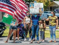  ??  ?? Supporters honoring Guillén hold signs near a memorial in her honor on Bustillos Drive on the South Side.