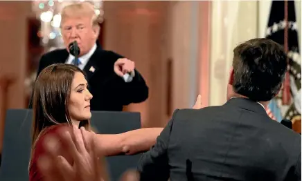  ?? AP ?? CNN’s Jim Acosta leans away as a White House aide tries to take the microphone from him during a news conference in the East Room of the White House.