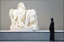  ??  ?? A woman looks at a statue titled ‘Horses of the Sun’ by French sculptor Gilles Guerin at the Louvre Abu Dhabi Museum during a media tour on Nov 6. (AFP)