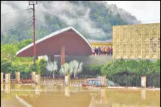  ?? AP ?? Hotel guests stand on the roof of a flooded hotel in Jim Corbett National Park, Uttarakhan­d, on Tuesday.