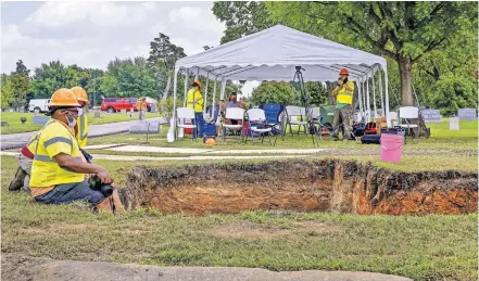  ?? [JORDAN GREEN PHOTOS/ THE OKLAHOMAN] ?? Workers with the City of Tulsa sit on the edge of a trench being excavated Wednesday in the search for mass graves at Oaklawn Cemetery.