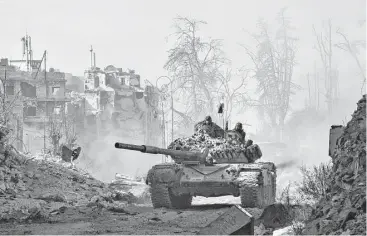  ?? George Ourfalian / AFP / Getty Images ?? Syrian pro-government forces maneuver a tank Thursday in a newly retaken area in Aleppo’s Old City. President Bashar Assad said victory for his forces in Aleppo would be a “huge step” in ending Syria’s war.