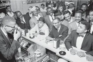  ?? Photo by Bob Gomel used with permission of the artist ?? Malcolm X takes a photograph of Muhammad Ali on Feb. 25, 1964 in Miami. Ali was a controvers­ial and conciliato­ry figure who sparked the nation’s conscience. Where are the Alis of today?