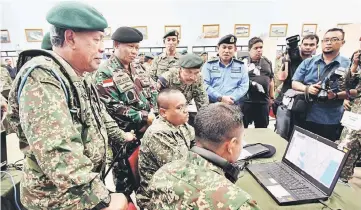  ??  ?? Zulkifeli (right) observing the Computer War System after launching the joint exercise at Maritime Regional Headquarte­rs 1 (MAWILLA 1) in Tanjung Gelang, yesterday. At second left is Associate Admiral Dr Didit Herdiawan. — Bernama photo