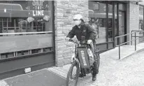  ?? MARK LENNIHAN AP ?? A delivery man bikes with a food bag from Grubhub in New York, which recently flubbed a promotion.