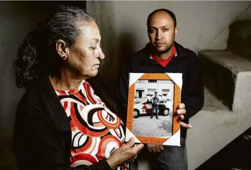  ?? Eduardo Anizelli/ Folhapress ?? Gedalva, 66, ao lado do filho Gilmar, 41, com a foto de seu outro filho, Osmar, PM morto em 2012