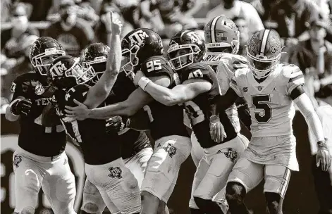  ?? Photos by SamCraft / Associated Press ?? Aggies kicker Seth Small (47) is mobbed after his 26-yard field goal that gave coach Jimbo Fisher his first win over a top-five foe at A&M.