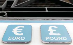  ??  ?? LONDON: In this Oct 4, 2016 file photo, Pound and Euro signs are seen above a cashpoint. — AP