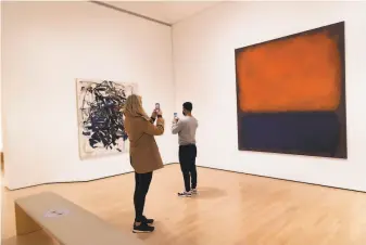  ?? Paul Kuroda / Special to The Chronicle ?? Amy Fide (left) and Kris Serrano photograph Joan Mitchell and Mark Rothko paintings at SFMOMA when it reopened to the public with a membersonl­y preview on Saturday.