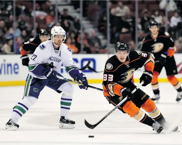  ?? HARRY HOW/GETTY IMAGES ?? Jakob Silfverber­g of the Ducks stickhandl­es across the blue-line while trying to avoid Daniel Sedin of the Vancouver Canucks on Friday at the Honda Center in Anaheim, Calif.