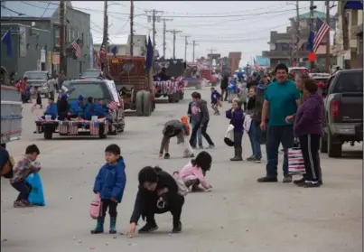  ?? Photo by James Mason ?? PARADE SCRAMBLE— Kids grabbed at the candy tossed from vehicles as the Nome Fourth of July parade made its way down Front Street Saturday.